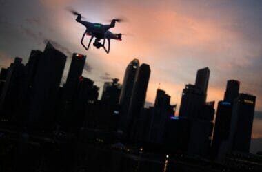 silhouette of quadcopter drone hovering near the city